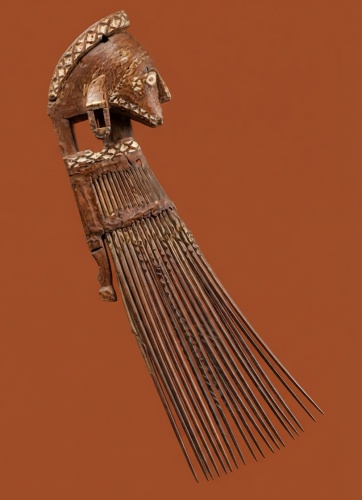 Peigne en bois sculpté avec des motifs décoratifs, représentant une tête stylisée et de longues dents.