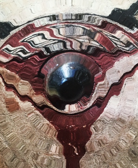 Image d'un motif circulaire en mouvement avec des nuances de rouge et noir, créant une impression dynamique autour d'un élément central réfléchissant.